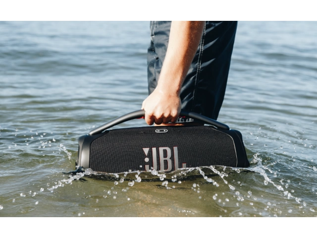 JBL Boombox 3 Wi-Fi Black junto a una piscina, demostrando su resistencia al agua con certificación IP67.