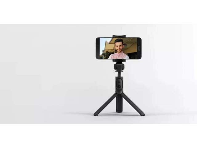 Xiaomi Mi Selfie Stick desplegado en modo trípode, mostrando su estabilidad y el control remoto Bluetooth. Ideal para fotos grupales. Avlis